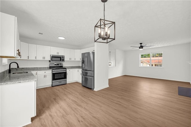 1645 Cobbs Creek Ln, Decatur, GA 30032 - kitchen featuring stainless steel appliances, a sink, open floor plan, light wood-type flooring, and ceiling fan