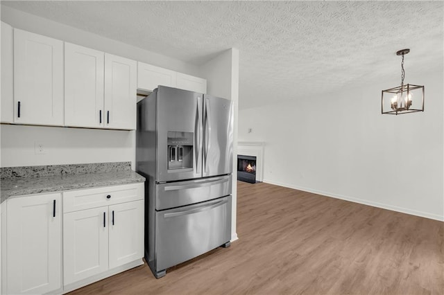 1645 Cobbs Creek Ln, Decatur, GA 30032 - kitchen featuring stainless steel fridge with ice dispenser, a chandelier, light wood-type flooring, and a textured ceiling