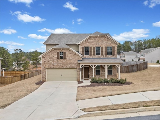 view of front of property with concrete driveway, brick siding, and fence