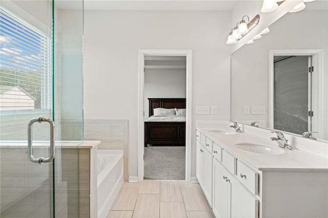 bathroom featuring a bath, ensuite bath, double vanity, and a sink