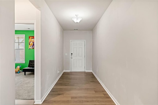 doorway to outside with wood finished floors, visible vents, and baseboards