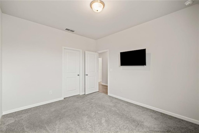 unfurnished bedroom featuring baseboards, visible vents, and carpet flooring