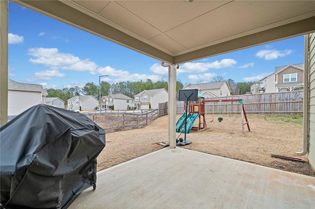 view of patio featuring a residential view, a playground, a fenced backyard, and area for grilling