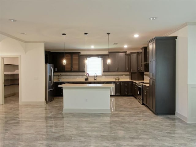 4590 River Stone Trl, Douglasville, GA 30135 - kitchen featuring appliances with stainless steel finishes, light countertops, arched walkways, a sink, and a center island