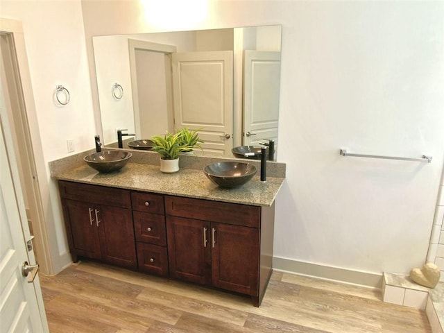 4590 River Stone Trl, Douglasville, GA 30135 - full bathroom with wood finished floors, double vanity, and baseboards