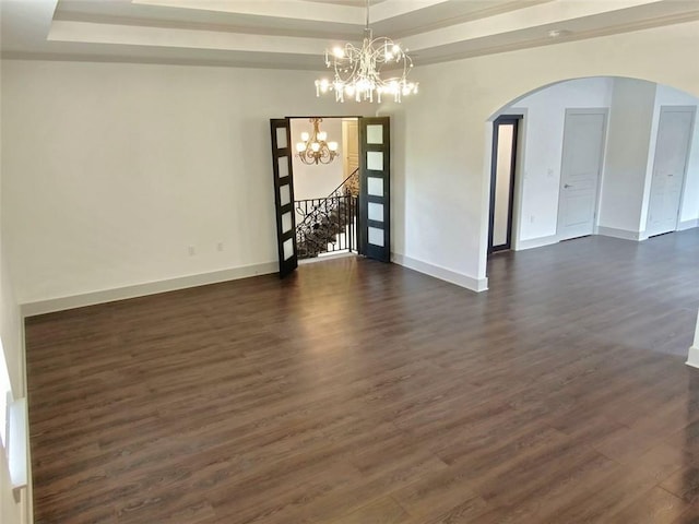 4590 River Stone Trl, Douglasville, GA 30135 - empty room featuring arched walkways, dark wood-style flooring, a chandelier, and baseboards