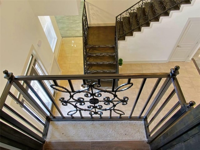 4590 River Stone Trl, Douglasville, GA 30135 - stairs featuring tile patterned flooring, baseboards, and a chandelier