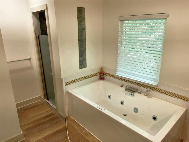 4590 River Stone Trl, Douglasville, GA 30135 - full bath featuring a jetted tub, wood finished floors, and a stall shower