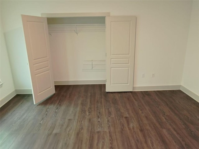4590 River Stone Trl, Douglasville, GA 30135 - unfurnished bedroom featuring baseboards, dark wood finished floors, and a closet