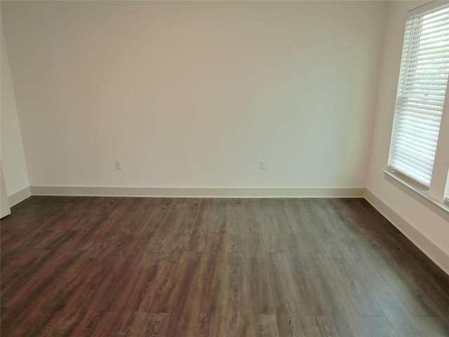 4590 River Stone Trl, Douglasville, GA 30135 - empty room featuring dark wood-type flooring, plenty of natural light, and baseboards