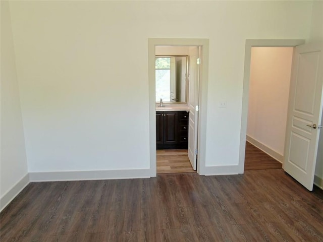 4590 River Stone Trl, Douglasville, GA 30135 - unfurnished bedroom featuring dark wood-style floors, baseboards, a sink, and ensuite bathroom