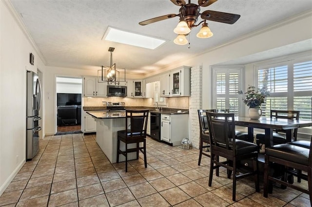 263 Mountainview Cir, Canton, GA 30115 - kitchen featuring stainless steel appliances, crown molding, dark countertops, a breakfast bar, and glass insert cabinets