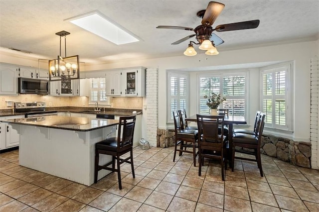 263 Mountainview Cir, Canton, GA 30115 - kitchen with appliances with stainless steel finishes, dark countertops, healthy amount of natural light, a kitchen breakfast bar, and a textured ceiling