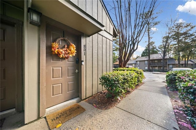 view of exterior entry with a residential view and board and batten siding