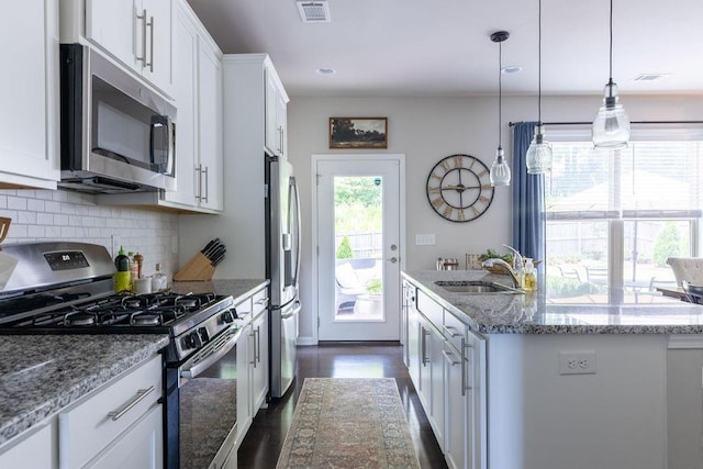 2099 Lakeview Bend Way, Buford, GA 30519 - kitchen featuring appliances with stainless steel finishes, a center island with sink, dark wood-style flooring, backsplash, and white cabinets