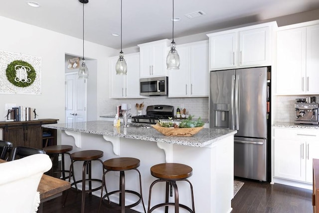 2099 Lakeview Bend Way, Buford, GA 30519 - kitchen featuring stainless steel appliances, decorative backsplash, a kitchen breakfast bar, a kitchen island with sink, and dark wood finished floors