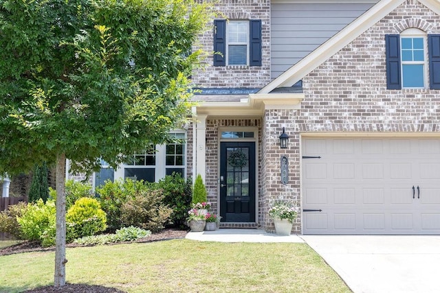 2099 Lakeview Bend Way, Buford, GA 30519 - property entrance with a yard, brick siding, driveway, and an attached garage
