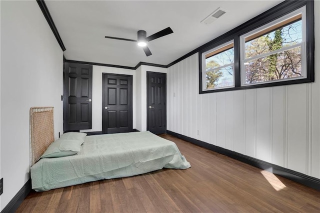 bedroom featuring hardwood / wood-style flooring, crown molding, and ceiling fan