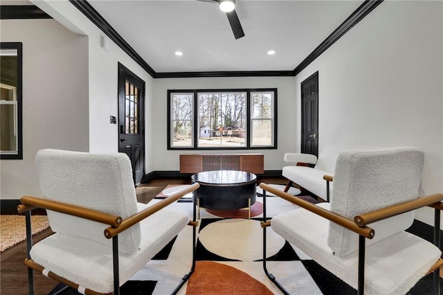 living area with wood-type flooring, ornamental molding, and ceiling fan