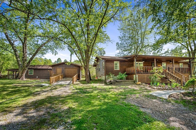 view of yard featuring driveway, a porch, an outdoor structure, and a garage