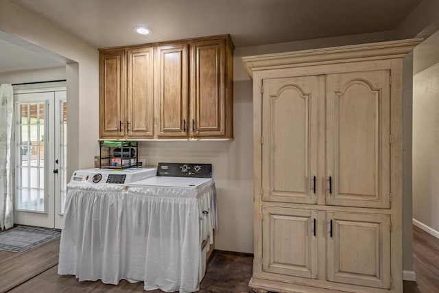 washroom with cabinet space, washer and clothes dryer, dark wood-style flooring, and baseboards