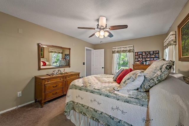 carpeted bedroom with a textured ceiling, baseboards, and ceiling fan