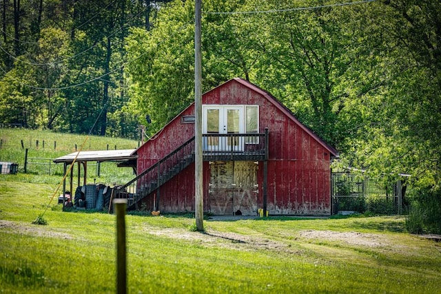 view of outbuilding with an outdoor structure, fence, and stairs