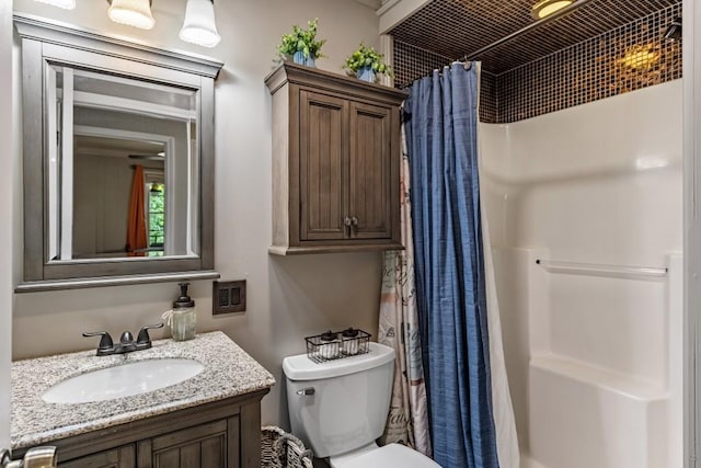 bathroom with toilet, vanity, and a shower with shower curtain