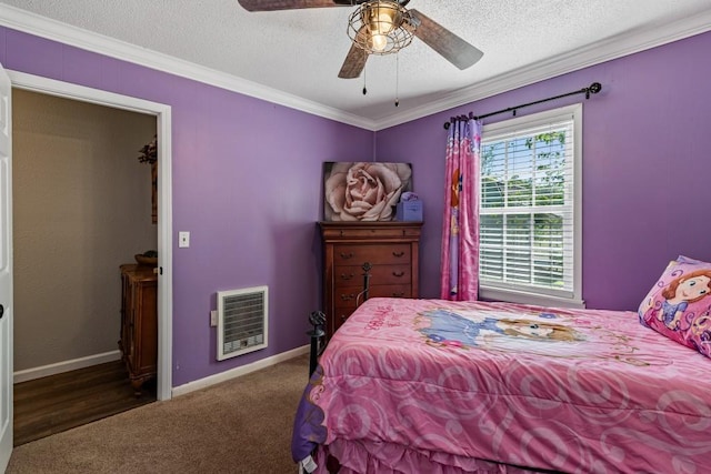 carpeted bedroom featuring heating unit, crown molding, a textured ceiling, and baseboards