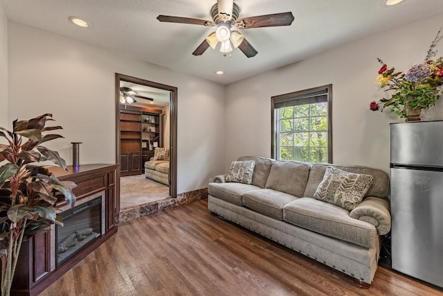living area with ceiling fan, recessed lighting, and wood finished floors