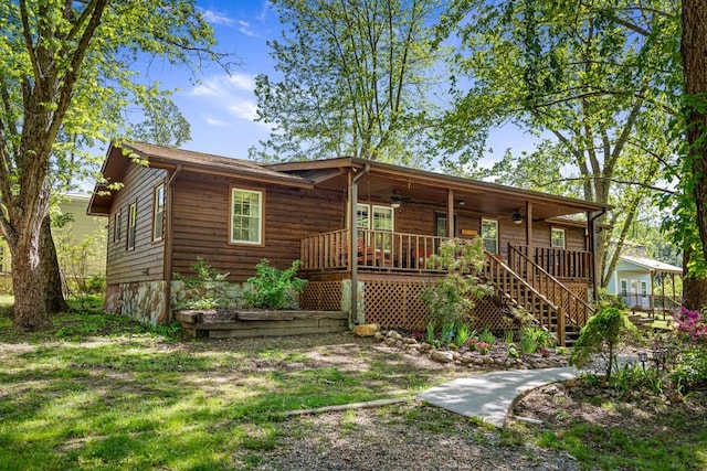 rustic home with covered porch, ceiling fan, and stairs