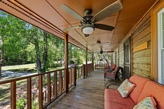 wooden terrace with a porch and ceiling fan