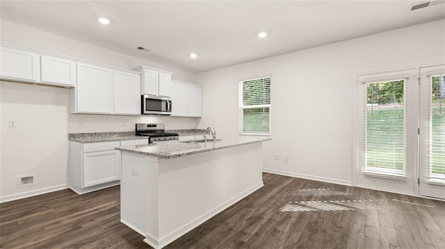 kitchen featuring appliances with stainless steel finishes, a sink, white cabinets, dark wood-type flooring, and recessed lighting