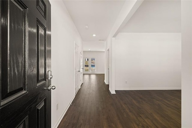 hallway with dark wood-type flooring, baseboards, and recessed lighting