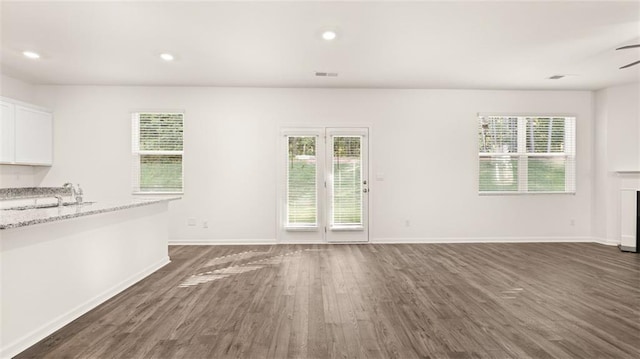 unfurnished living room featuring dark wood-style floors, baseboards, a sink, a ceiling fan, and recessed lighting