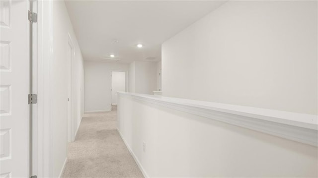 corridor with light carpet, recessed lighting, and baseboards