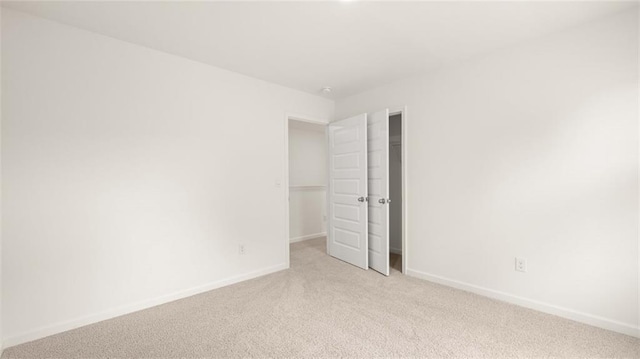 unfurnished bedroom featuring light colored carpet and baseboards