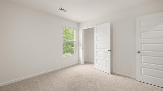 unfurnished bedroom with light carpet, baseboards, and a closet