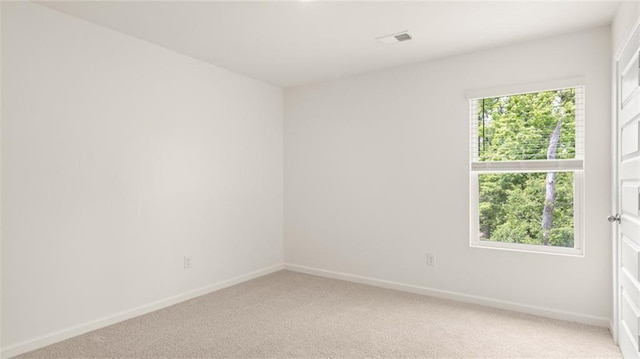unfurnished room featuring baseboards and light colored carpet