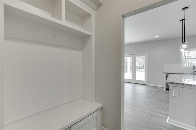 mudroom with french doors, recessed lighting, light wood-style floors, a sink, and baseboards