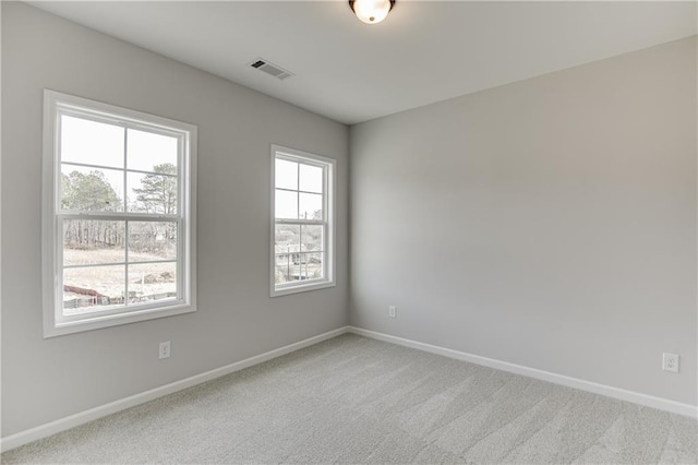 unfurnished room with baseboards, visible vents, and light colored carpet