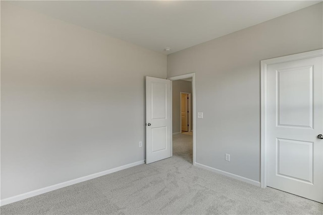 unfurnished bedroom featuring baseboards and light colored carpet