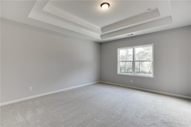 empty room with baseboards, visible vents, and a raised ceiling