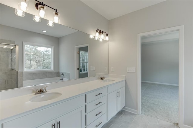 bathroom with double vanity, a sink, a shower stall, and a bath