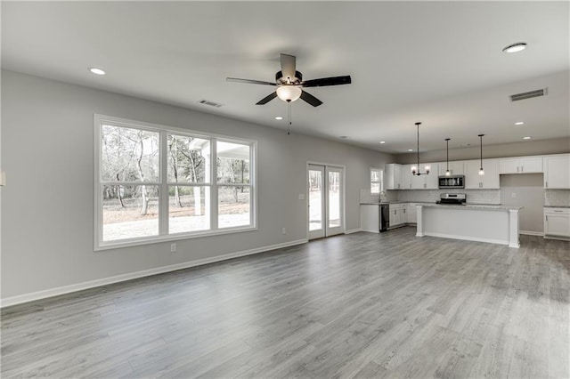 unfurnished living room featuring recessed lighting, visible vents, light wood-style flooring, and baseboards