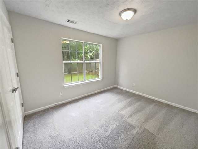 spare room with a textured ceiling and carpet floors