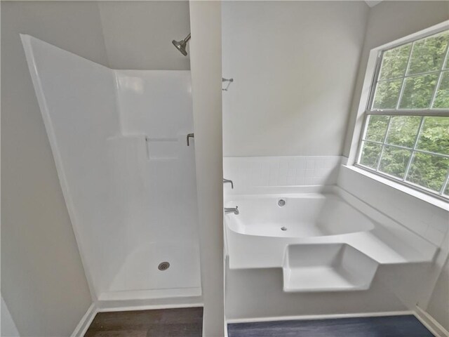 bathroom featuring independent shower and bath, a healthy amount of sunlight, and hardwood / wood-style flooring