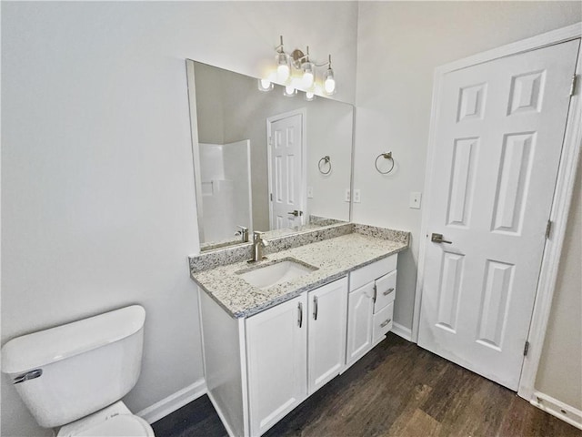 bathroom with toilet, hardwood / wood-style flooring, and vanity