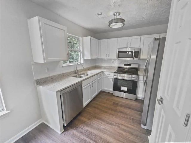 kitchen featuring white cabinetry, stainless steel appliances, dark wood-type flooring, and sink