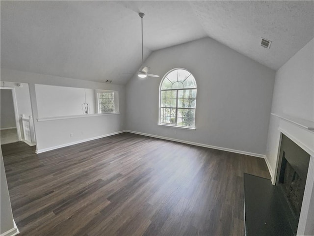 unfurnished living room featuring ceiling fan, a textured ceiling, lofted ceiling, and dark wood-type flooring